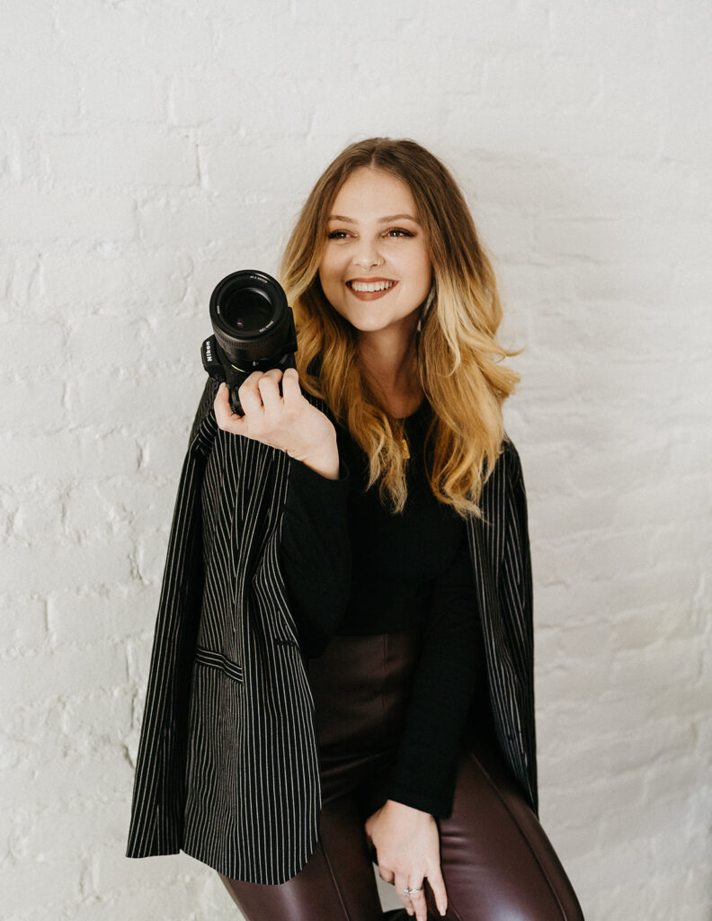 Kianna Martinez Photography 
Head shot of a photographer holding her camera. 