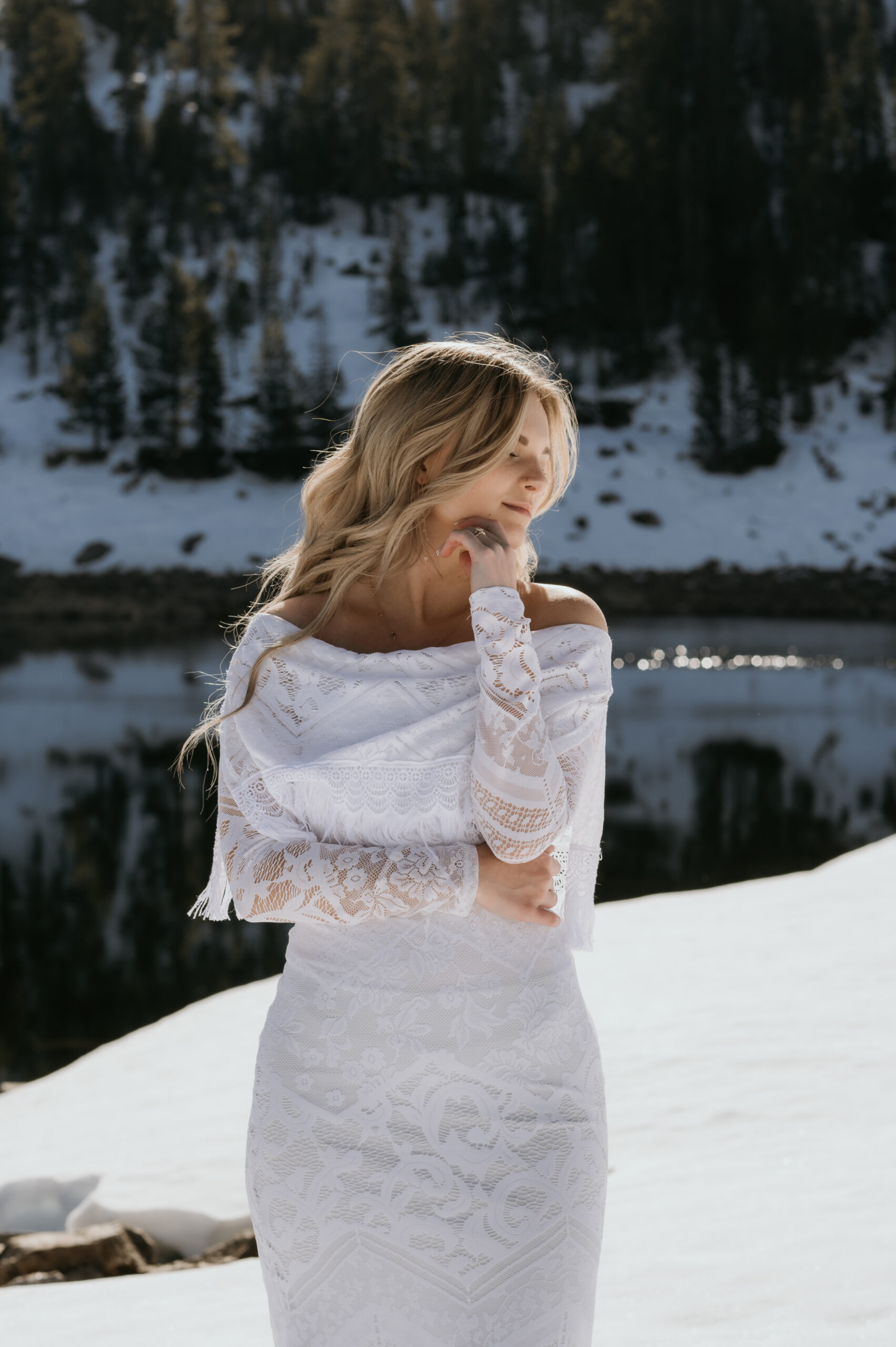 Bride’s lace gown flowing in Sierra Nevada mountain snow