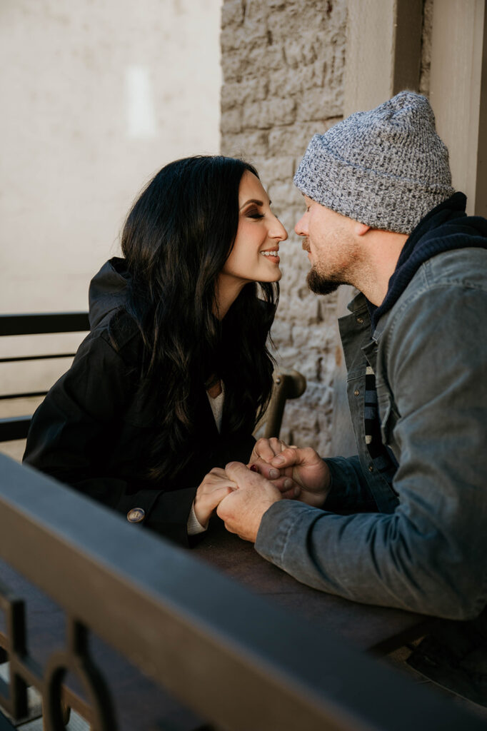 Sitting on the patio in sutter creek the couple leans in for a kiss during the couples photos