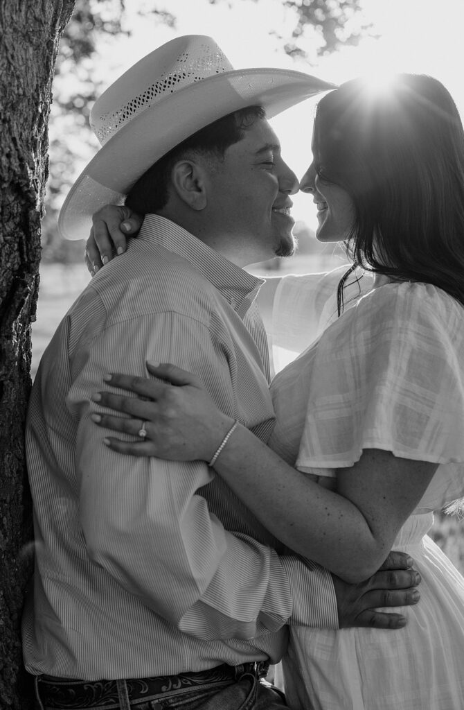 A b+w image shows a couple smiling and leaning into each other during a photoshoot with amador county photographer