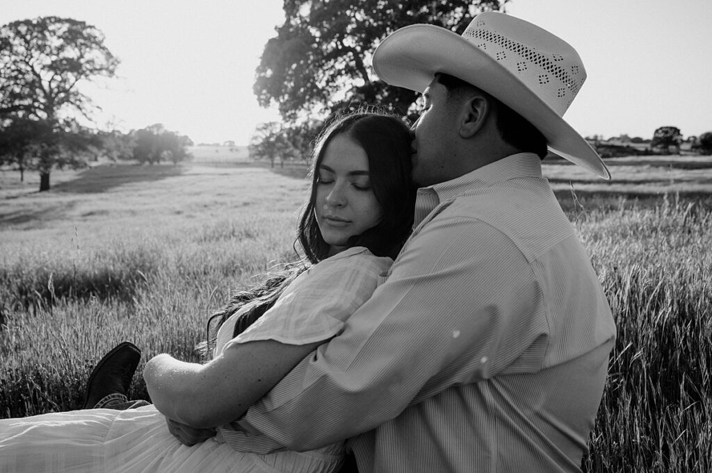 A b+w image taken by a california engagement photographer showcases a northern ca couple embracing for their engagement session on their farm