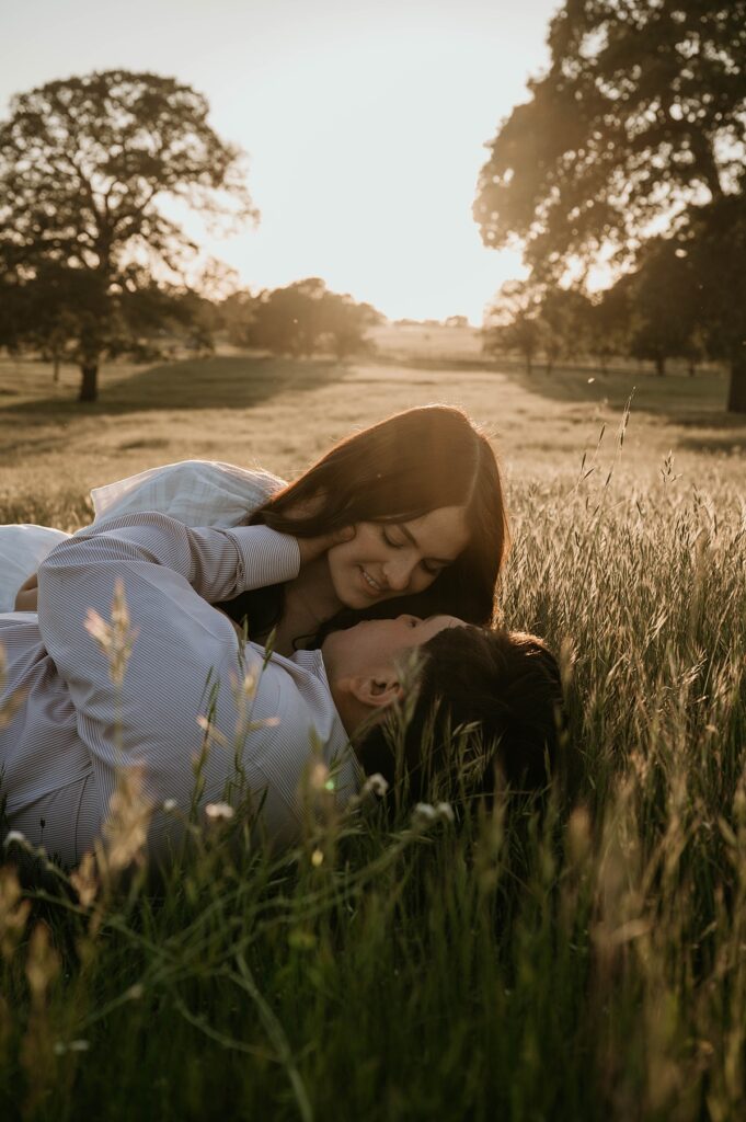 A young couple embrace in a field at golden hour during engagement photos with Kianna Martinez Photography, one of northern california wedding photographers who offers couples shoots 
