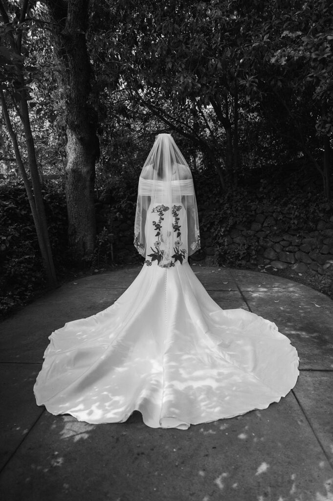 A wedding gown and embroidered veil are showcased in a black and white photo taken at one of California's wine country wedding venues