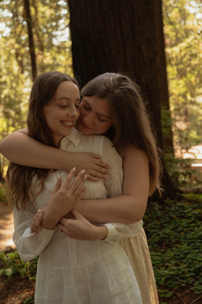 Joyful hug between a newly engaged couple in the redwood forest