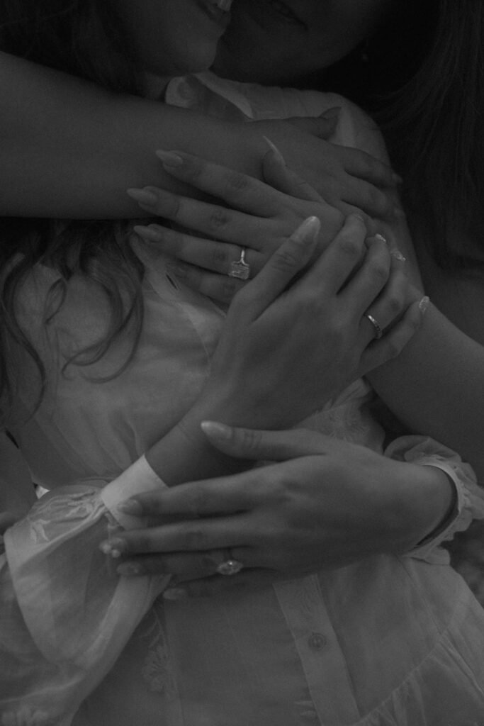 Close-up of clasped hands and engagement ring during a redwood proposal session